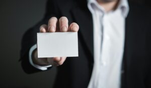 A man in a suit presenting a blank business card for corporate usage/ Digital Marketing Agency in Delhi NCR